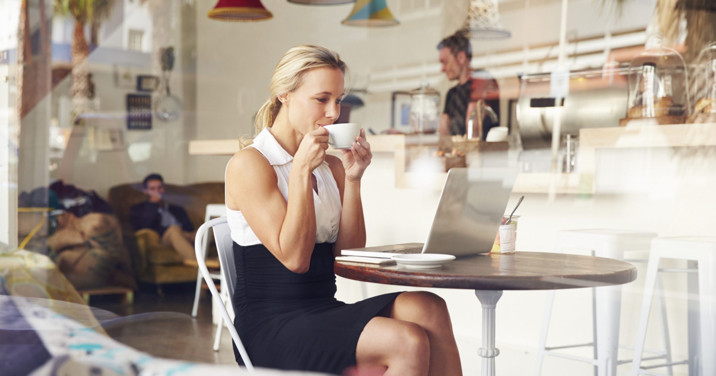Business woman sitting at a table in small coffee shop